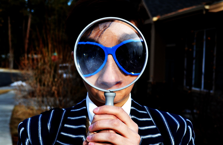 Person with a magnifying glass before his face