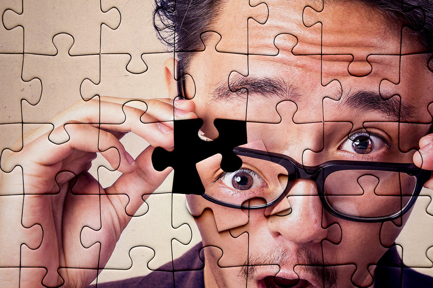 Jigsaw puzzle of surprised man with the last puzzle piece of the man's eye loose on top of the puzzle