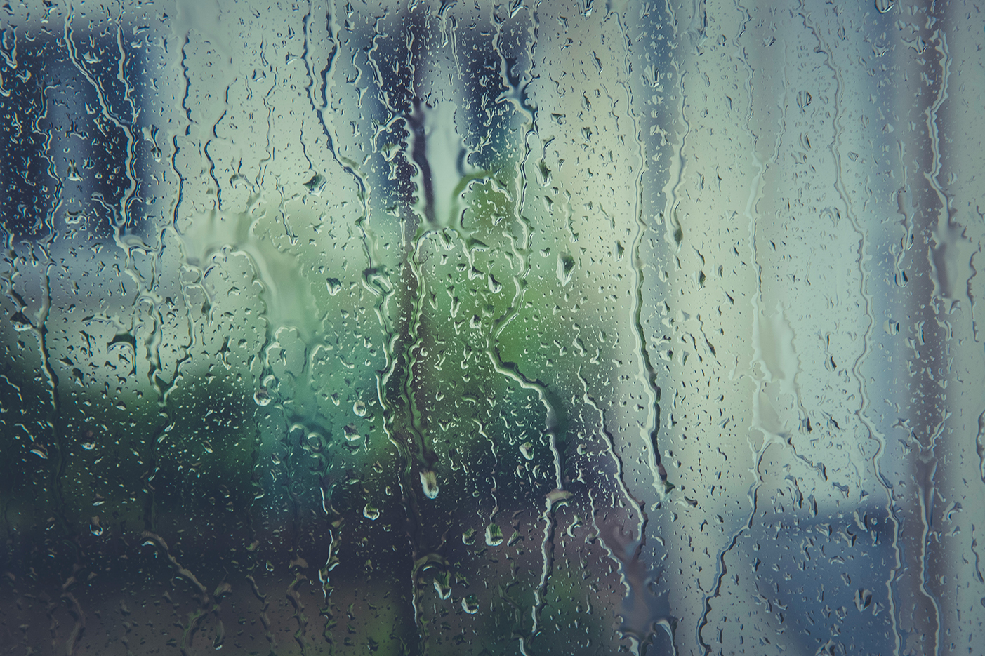 UItzicht naar buiten door met regendruppels beslagen raam