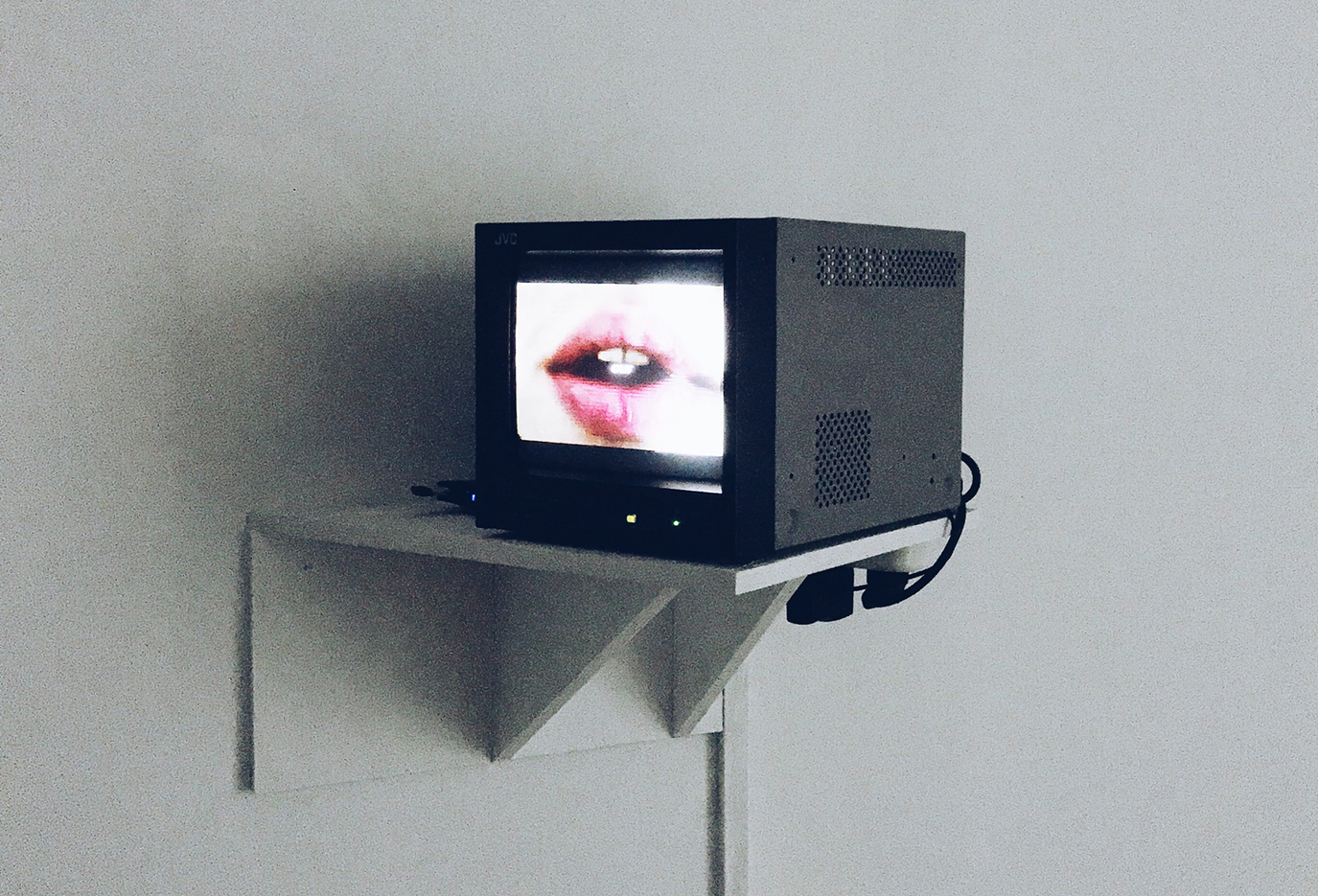 Monitor aan de muur met sprekende mond op het scherm